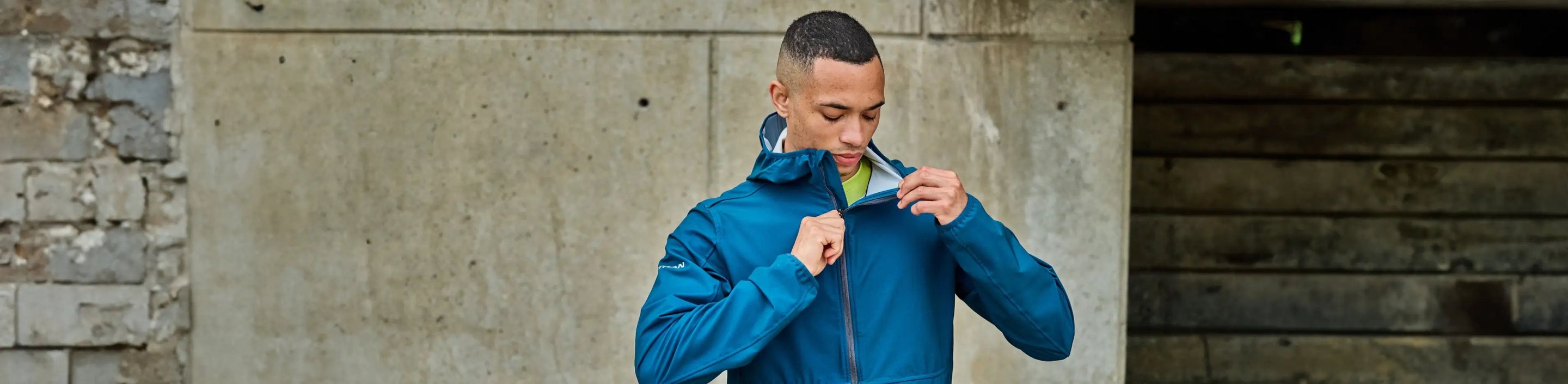 male zipping up a Nathan Sports hooded jacket